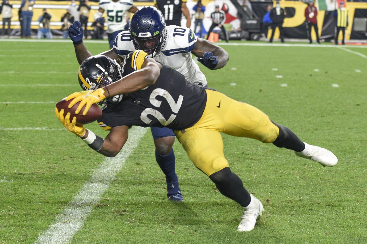 Pittsburgh Steelers running back Najee Harris (22) dashes past Seattle Seahawks defensive end Benson Mayowa (10) on his way to the end zone and a touchdown during the first half an NFL football game, Sunday, Oct. 17, 2021, in Pittsburgh. (AP Photo/Don Wright)