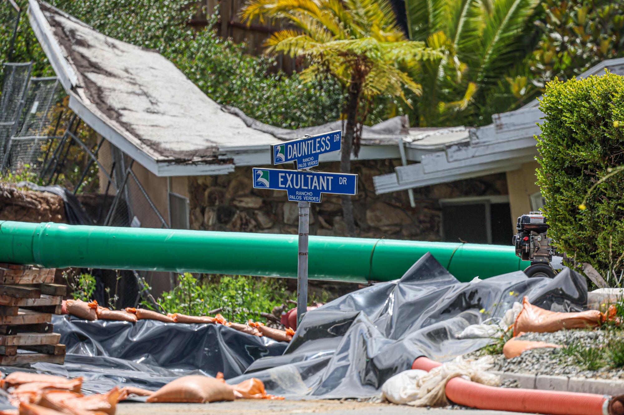 A tarp covers the street where a large fissure toppled a few homes last year in Rancho Palos Verdes.