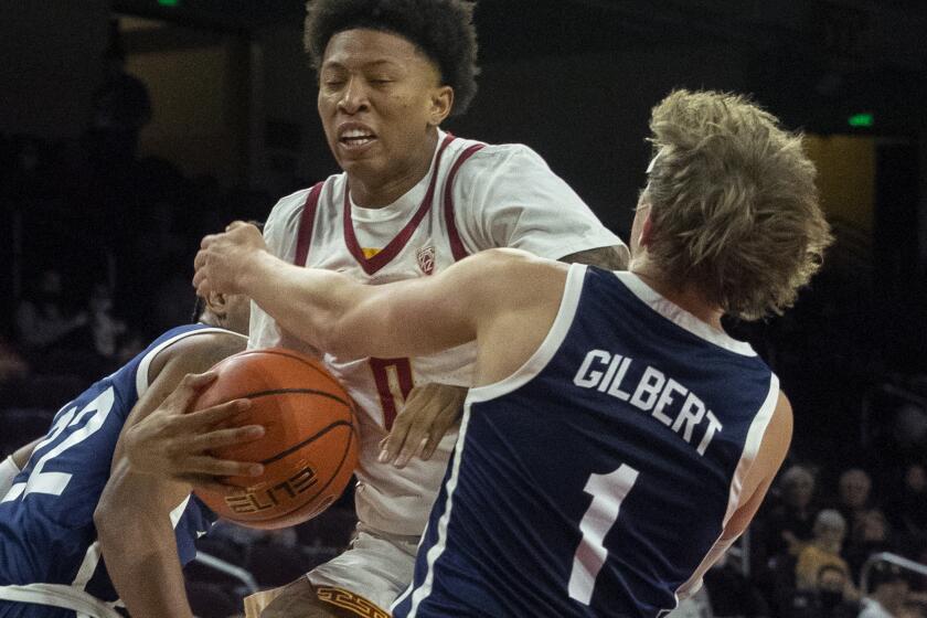LOS ANGELES, CA - November 22 2021: USC Trojans guard Boogie Ellis (0), left, is tied up under the rim by Dixie State Trailblazers Brock Gilbert (1) during first half at the Galen Center on Monday, Nov. 22, 2021 in Los Angeles, CA. (Brian van der Brug / Los Angeles Times