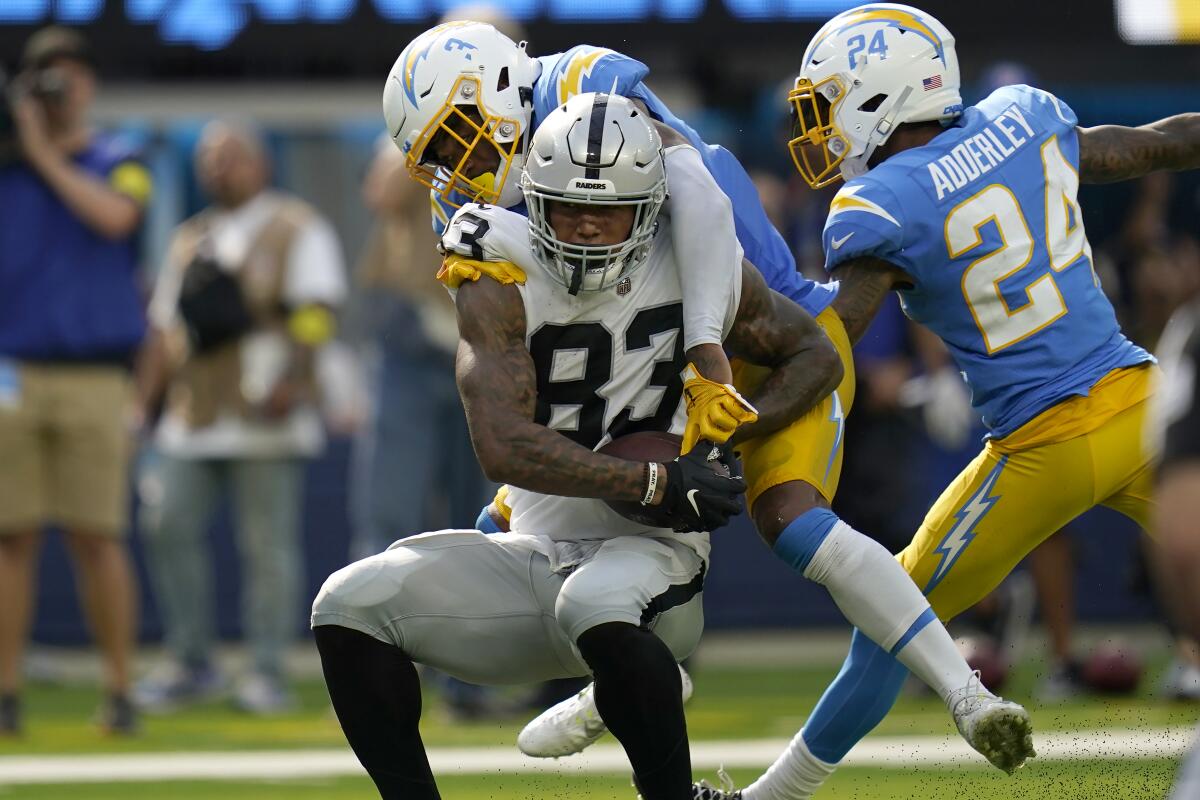 Raiders tight end Darren Waller (83) is tackled by Chargers safety Derwin James Jr. in the second half.