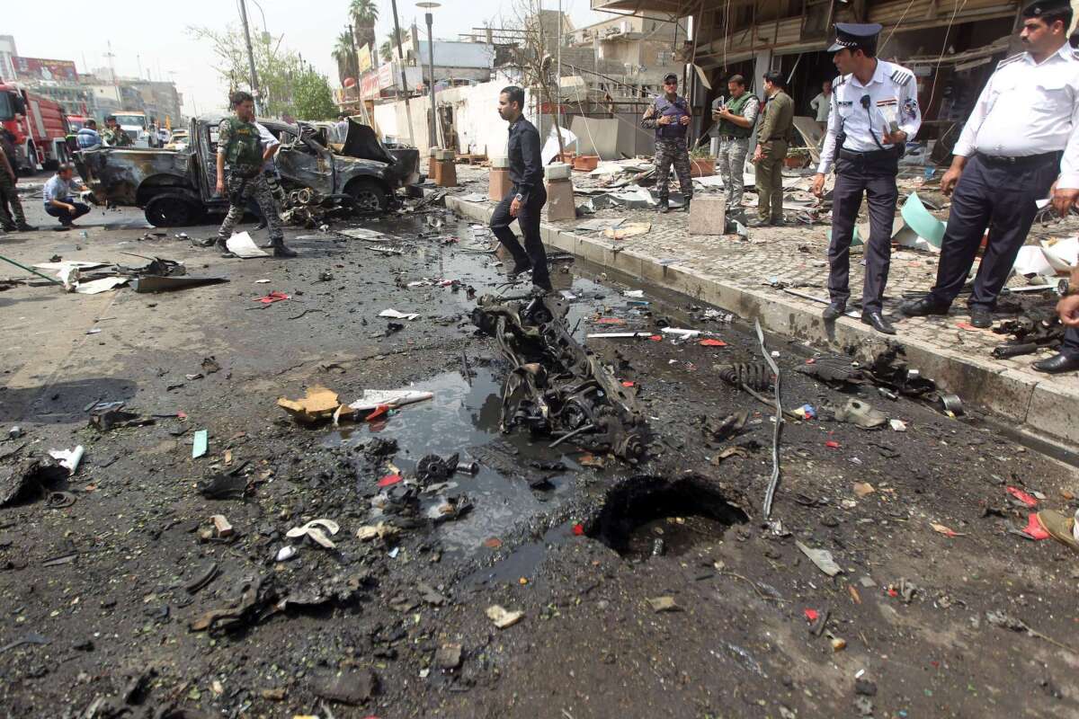 Iraqi security forces inspect the scene of a car bomb blast targeting Shiite pilgrims on an annual march to a Baghdad shrine which killed at least seven people Saturday.