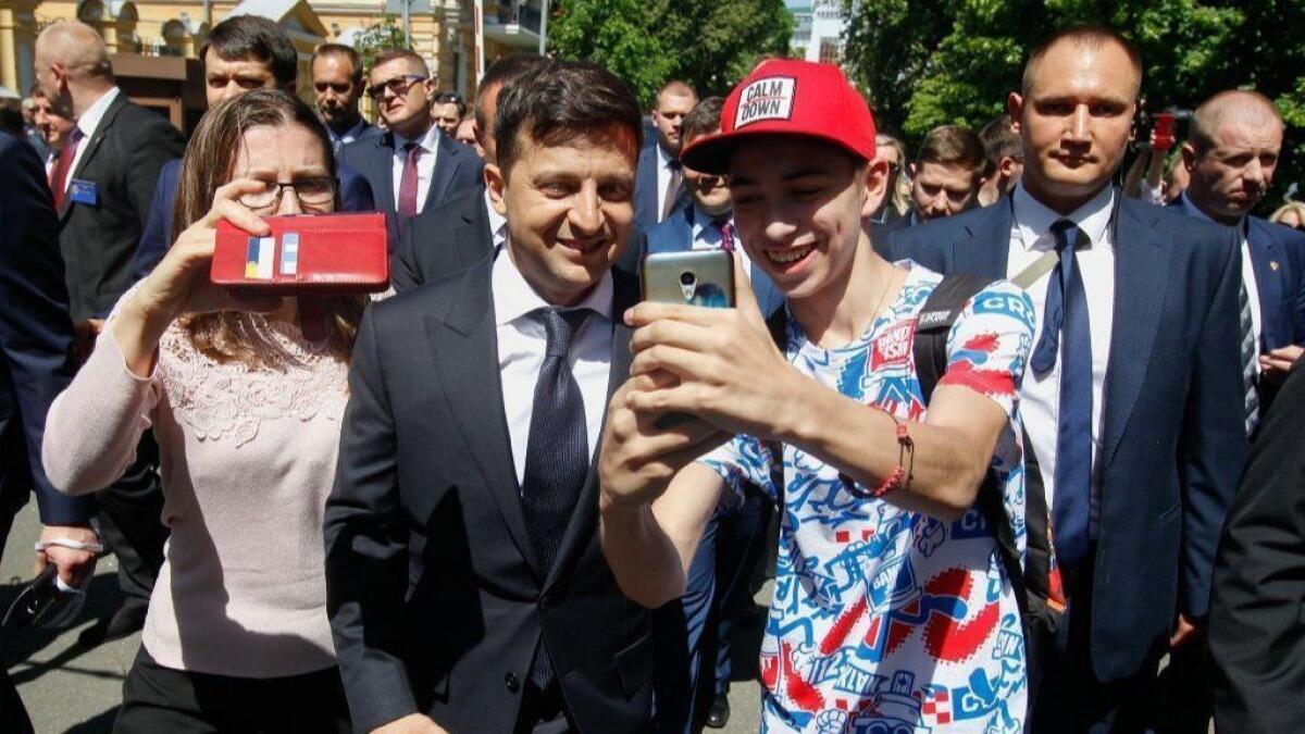 Ukrainian President Volodymyr Zelensky poses for selfies with supporters as he walks to the presidential office after his inauguration in Kiev, Ukraine, on May 20.