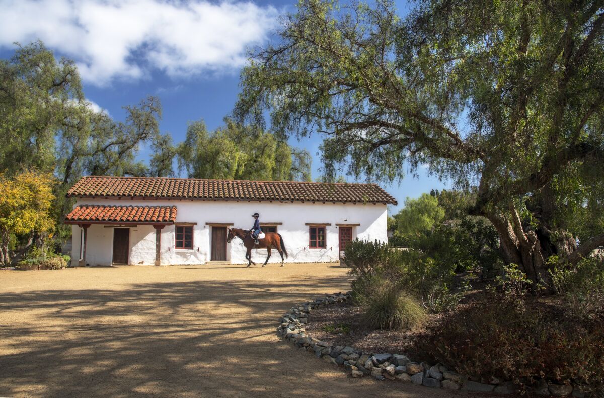 A rider on horseback passes the Juan Maria Osuna Ranch, one of the oldest adobe homes built in San Diego County. 
