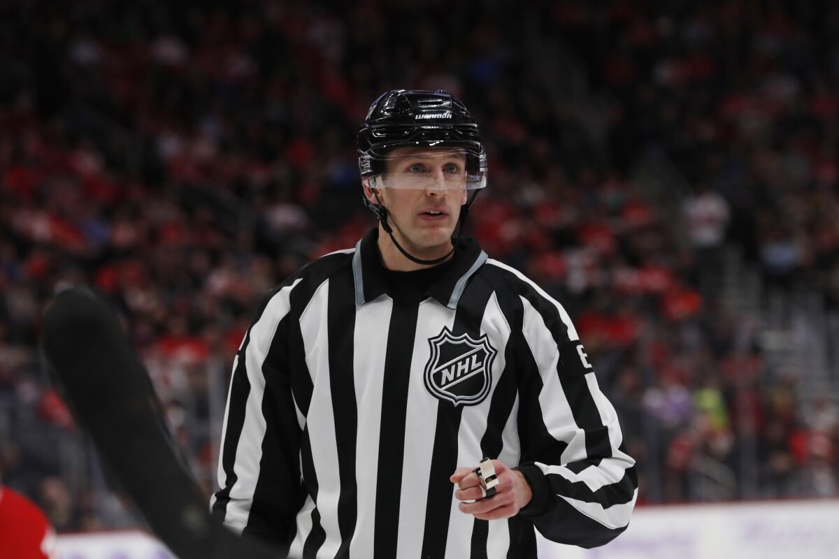 FILE - Linesman Ryan Daisy is seen during the second period of an NHL hockey game between the Detroit Red Wings and the Boston Bruins, Friday, Nov. 8, 2019, in Detroit. Daisy embraces the pressure of making important calls when games matter most. Being on water — frozen and otherwise — is Daisy’s comfort zone. (AP Photo/Carlos Osorio, File)
