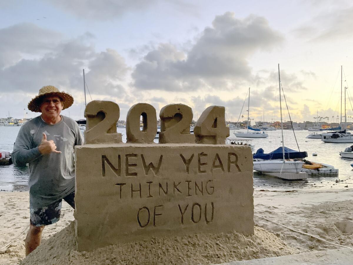 Chris Crosson, also known as the Sandcastle Builder, with his New Year message on the sand.