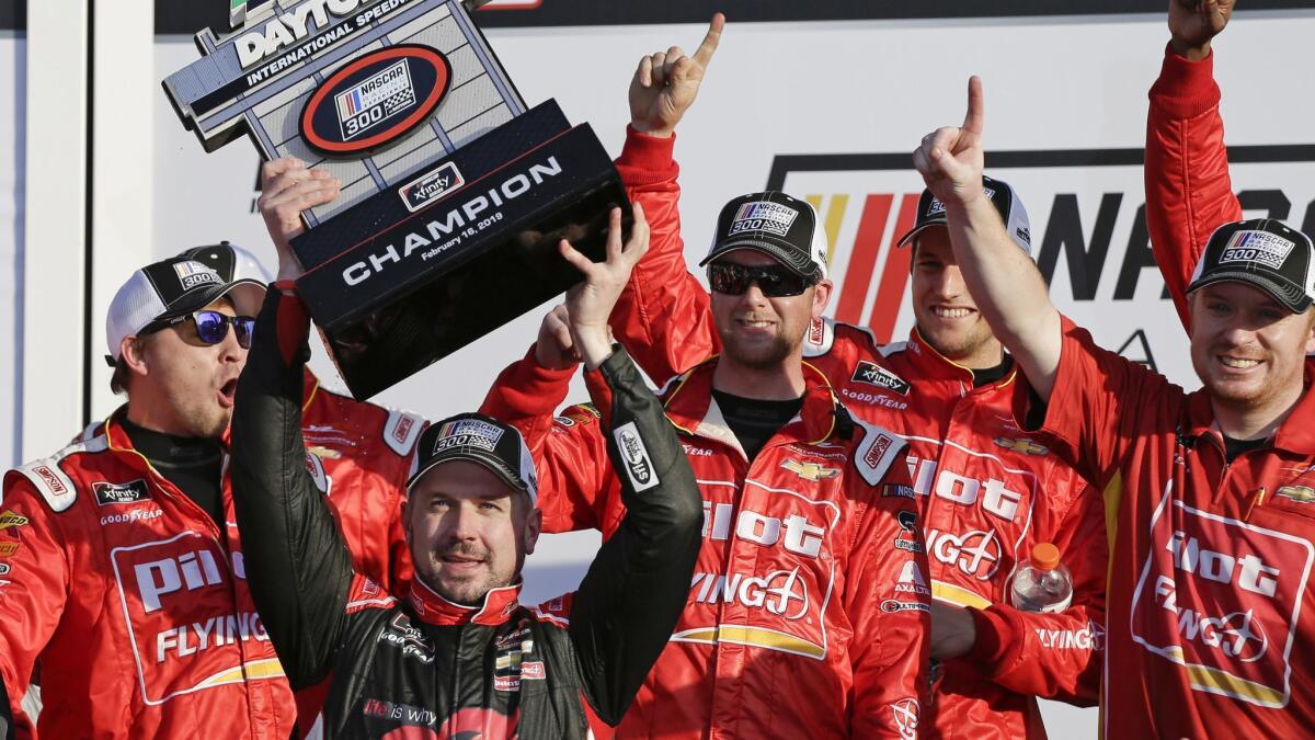 Michael Annett, front left, holds up the championship trophy after winning the NASCAR Xfinity Series auto race at Daytona International Speedway on Saturday in Daytona Beach, Fla.