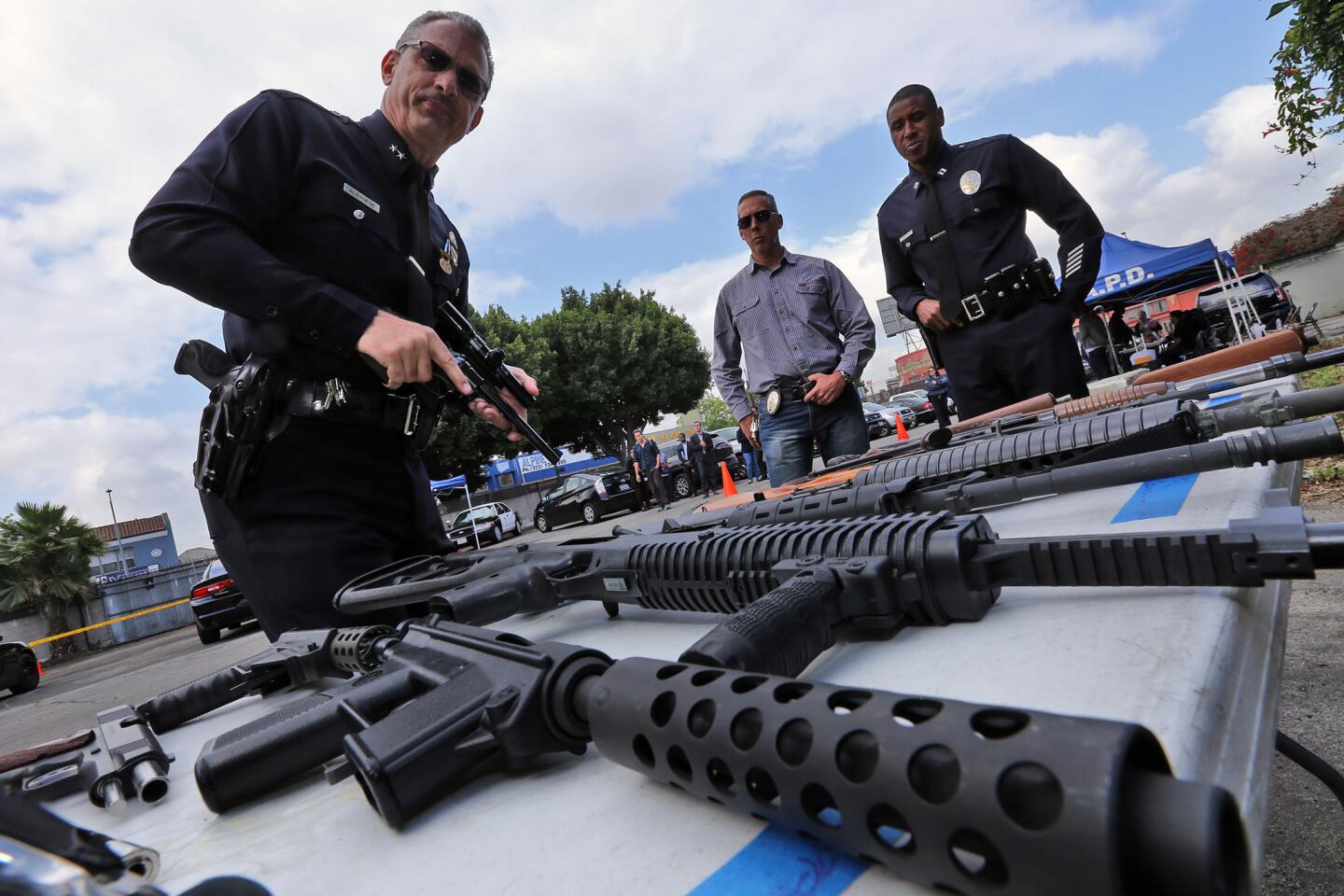 Deputy Chief Kirk J. Albanese checks out a gun brought in as part of the city's gun buyback program Saturday morning. The gun buyback is part of Mayor Eric Garcetti's Gang Reduction and Youth Development Office. It took place at a parking lot at 2379 W. Washington Blvd. in West Los Angeles.