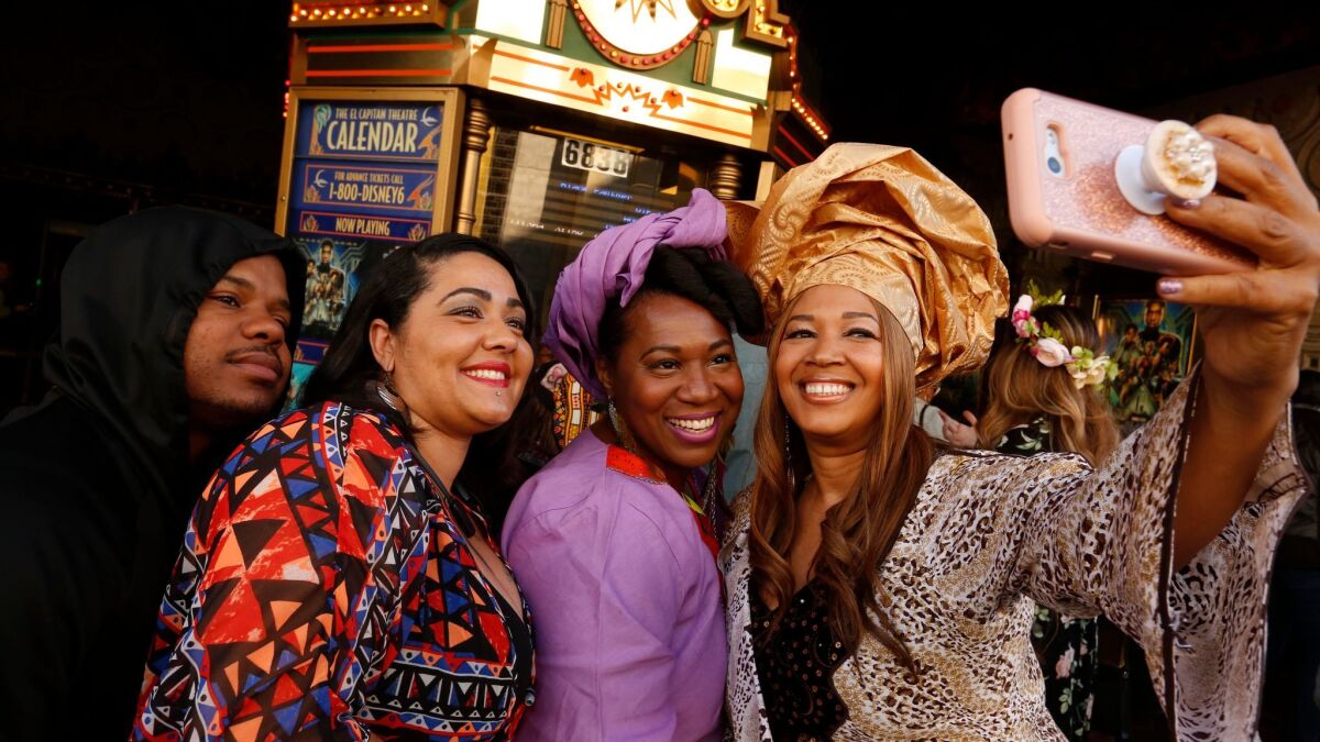 Cheyenne Martin, from right, takes a selfie with friends Chanell Jones-Harris, Lisa Lee and Play Bizness before attending a screening of "Black Panther" at the El Capitan Theatre on Saturday.