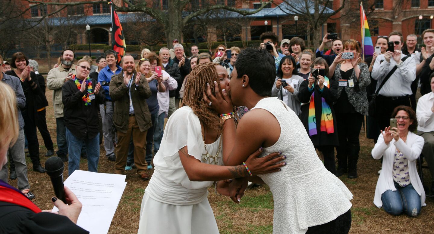 Yashinari Effinger kisses Adrian Thomas as they are declared a married couple by the Rev. Ellin Jimmerson in Big Spring Park in Huntsville, Ala.