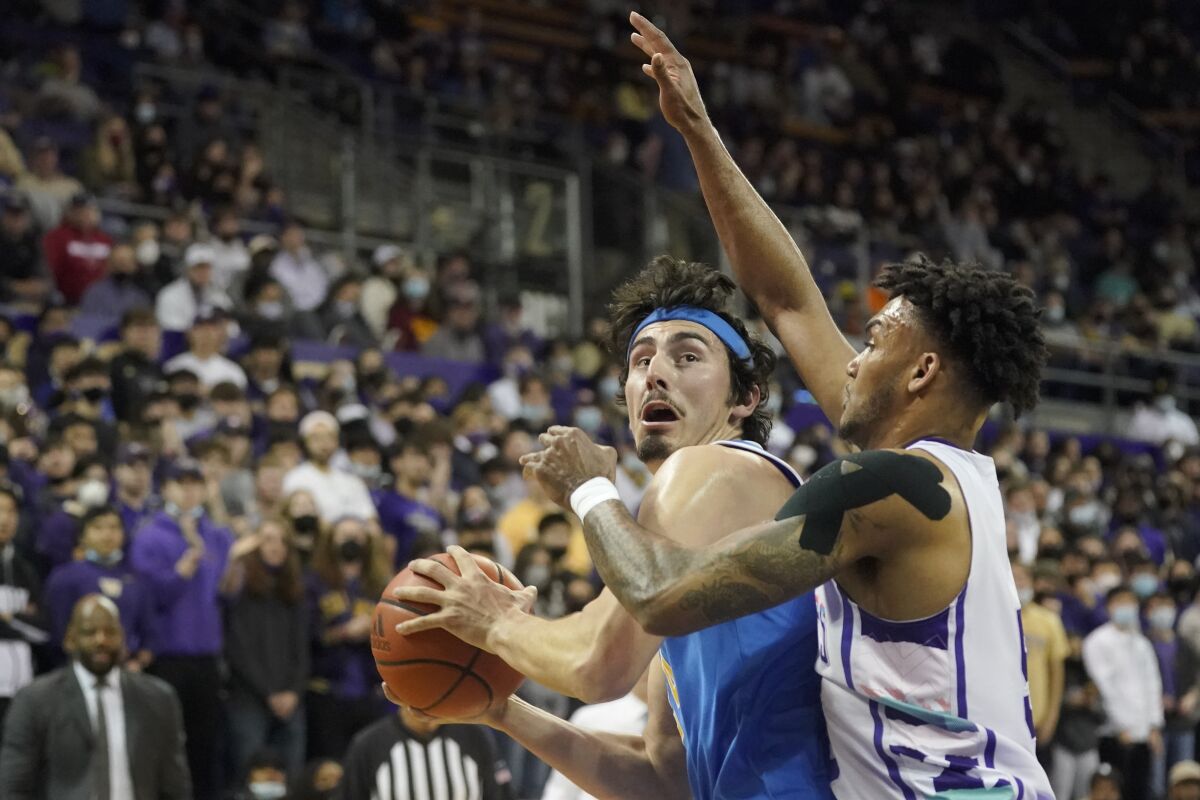 UCLA guard Jaime Jaquez Jr., left, is guarded by Washington guard Jamal Bey, right, during the first half of an NCAA college basketball game, Monday, Feb. 28, 2022, in Seattle. (AP Photo/Ted S. Warren)