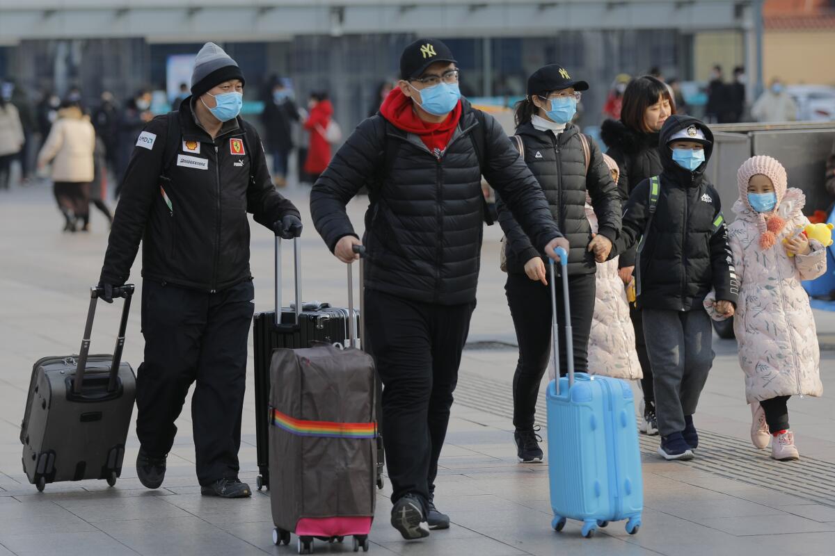 Pasajeros chinos usan máscaras en la estación de trenes de Beijing, el viernes. El brote de coronavirus se extendió hasta ahora desde China a EE.UU, Tailandia, Corea del Sur, Japón, Singapur y Taiwán.