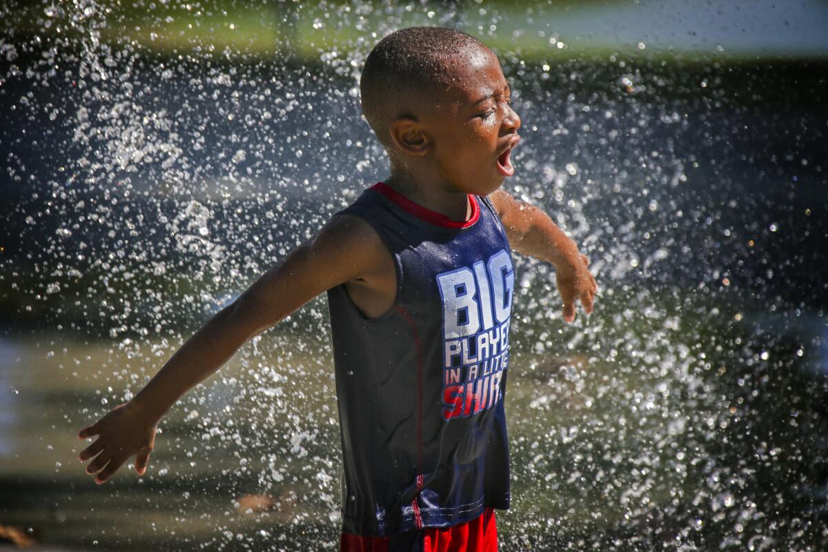 Jonah Stovall, 5, cools off on a hot afternoon at Cucamonga-Guasti Regional Park in Rancho Cucamonga.