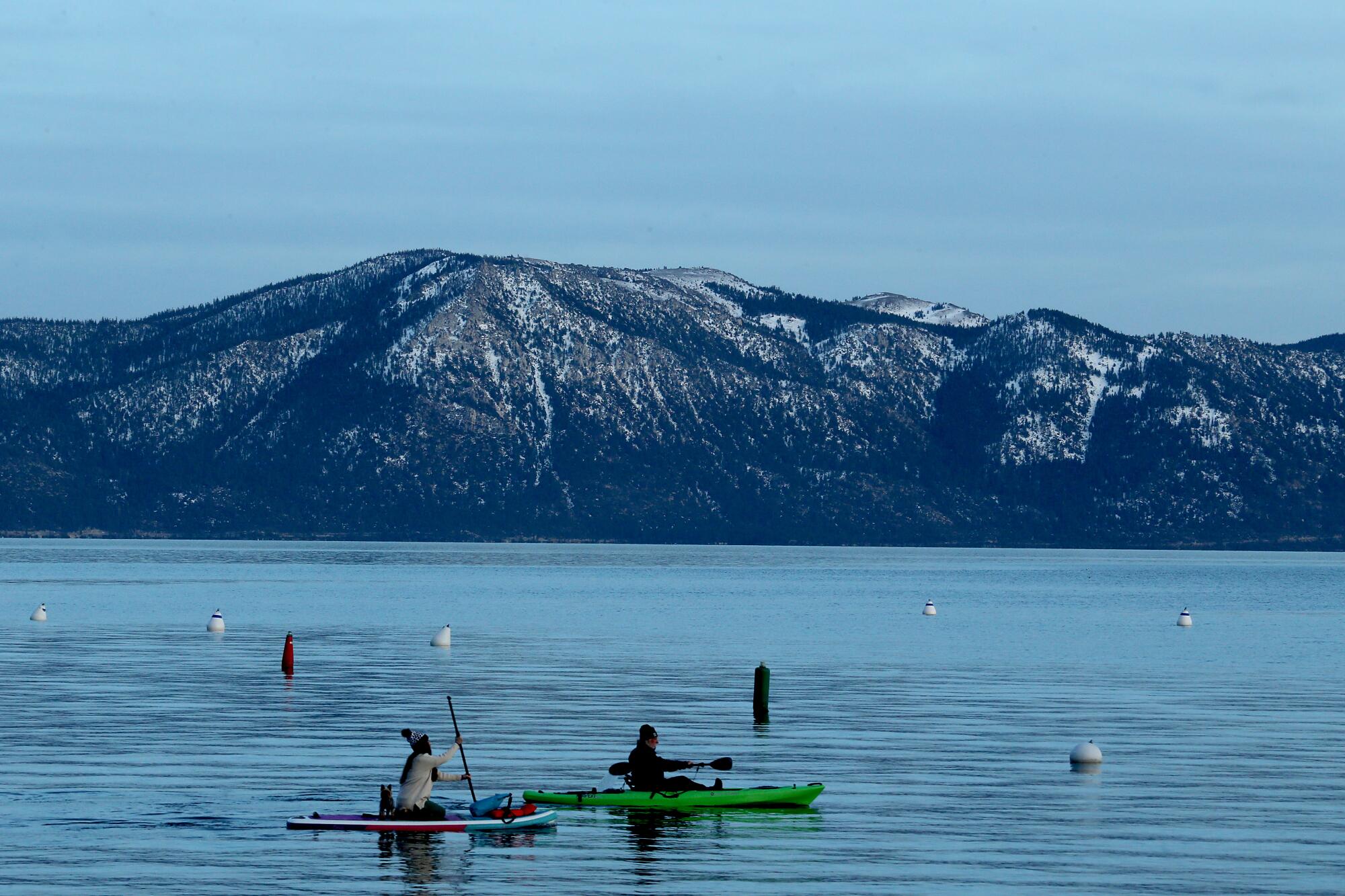 A paddle boarder and a kayaker glide across the surface of Lake Tahoe's frigid waters on Jan. 11.