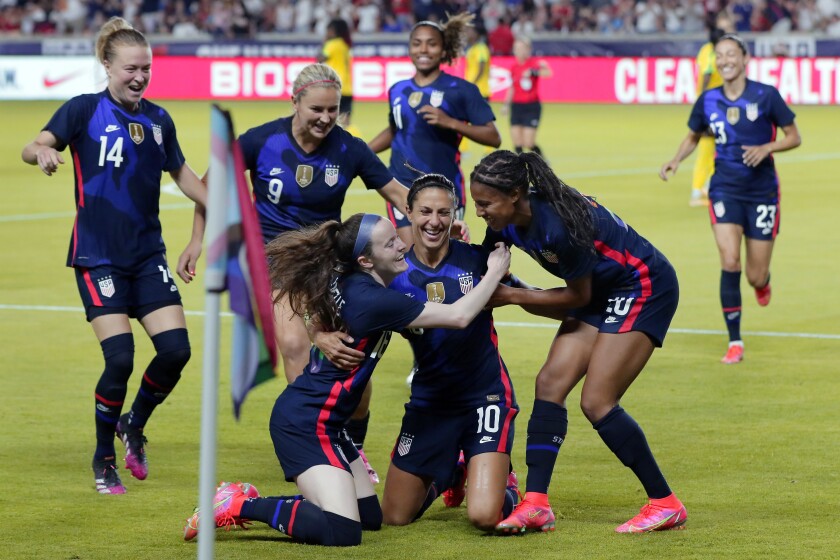 USA forward Carli Lloyd is swarmed by her team mates after scoring a goal against Jamaica.