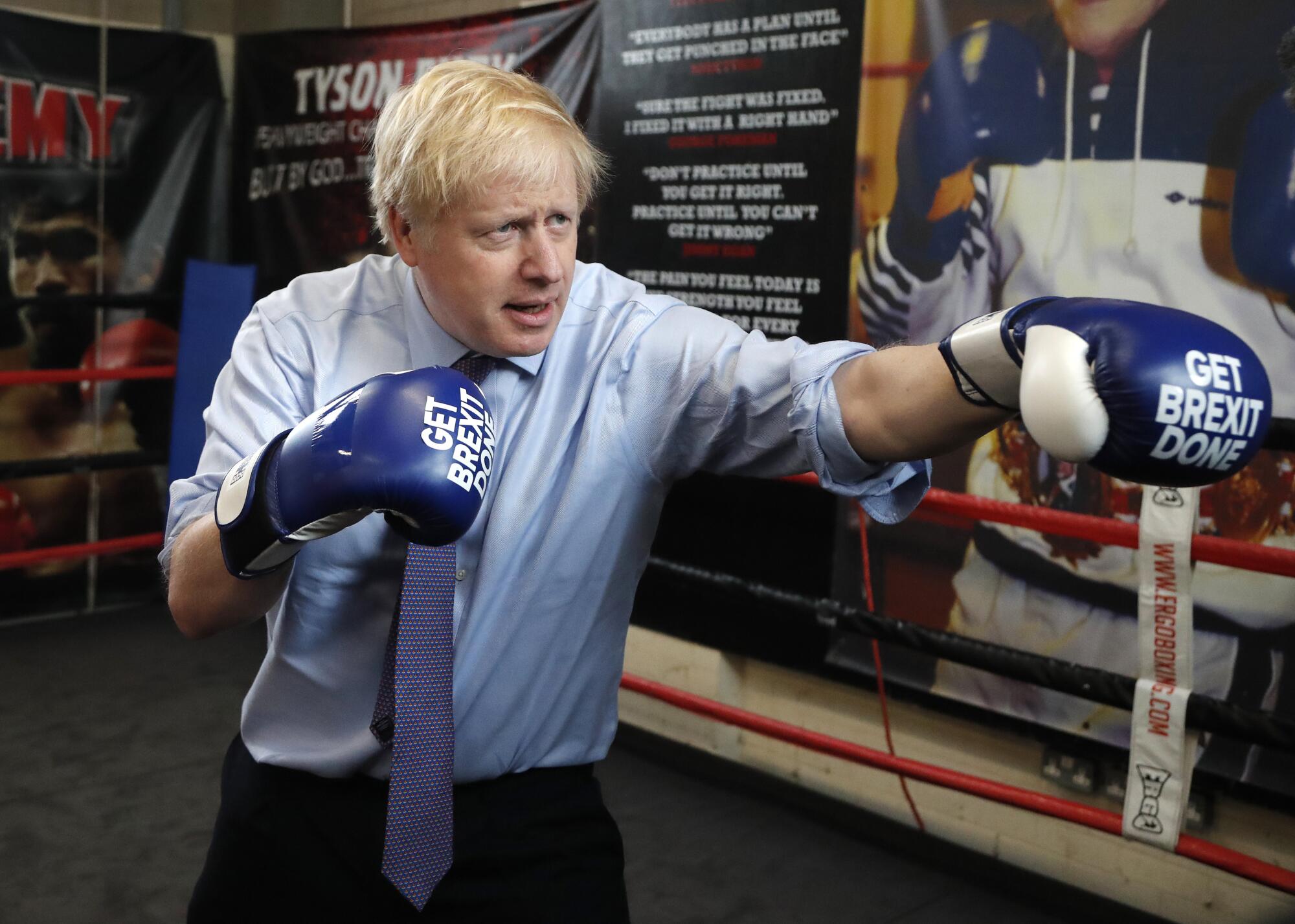 Britain's Prime Minister Boris Johnson poses for a photo wearing boxing gloves during a stop