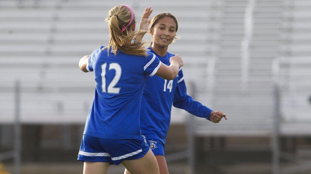 Fountain Valley High's Samantha Valdez (14) is congratulated by teammate Haley Wittick (12) after scoring a free kick against Ocean View.