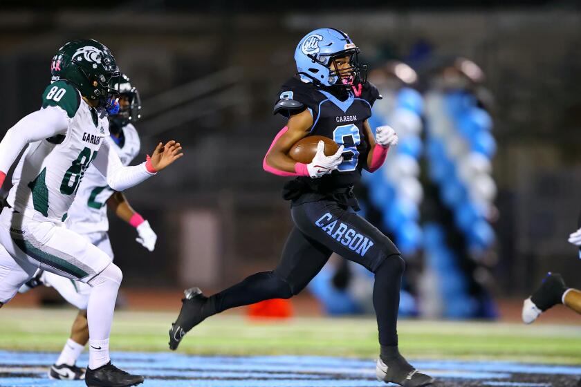 Carson High's Craig Walker tries to outrun Gardena defenders during a 23-7 win Friday night.