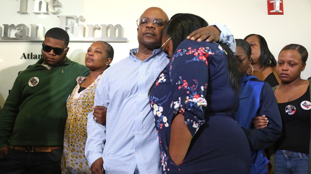 Charles Twyman, the father of Ryan Twyman, comforts his daughter Chiquita Twyman