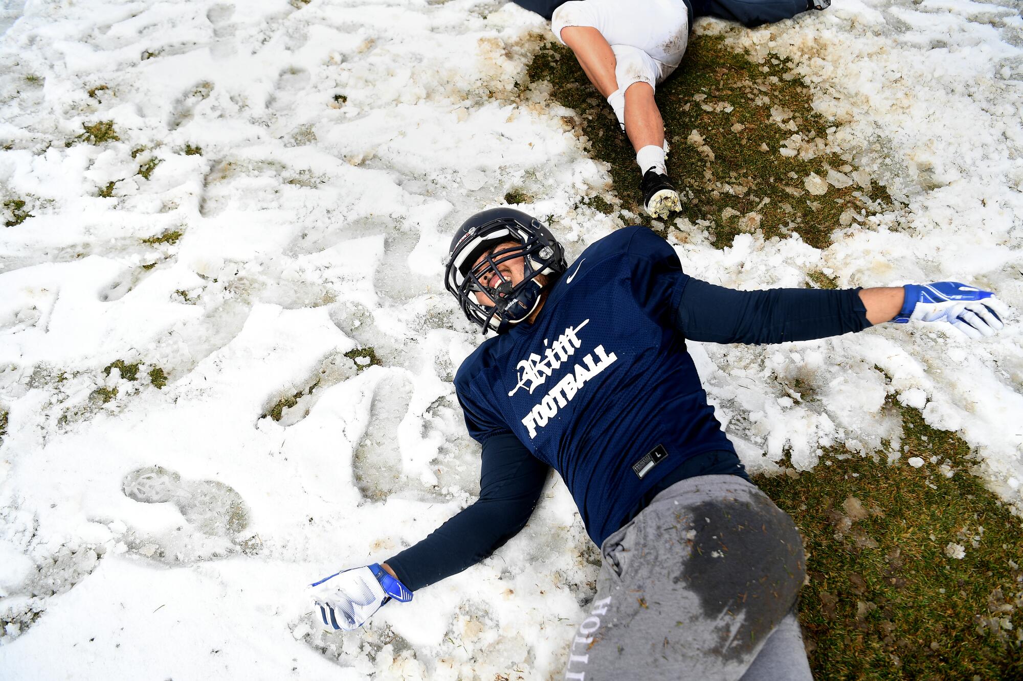 Adrian Molina stretches on the practice field after a snowstorm.