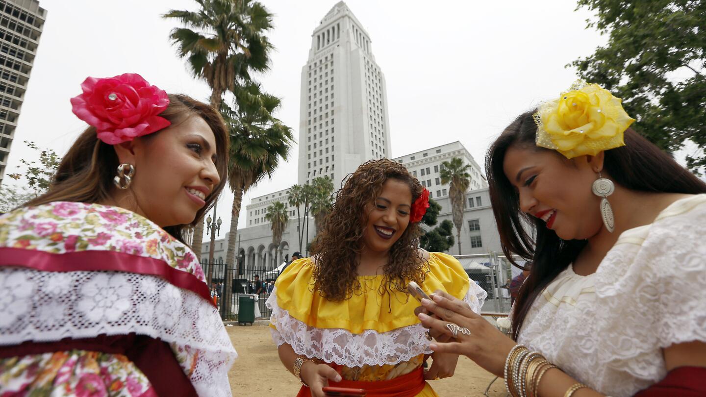 Janet Arteaga, from left, Gaby Arteaga, middle, and Luli Arteaga, known as the musical group Las Hermanas Arteaga, wait to go on stage at the 27th Fiesta Broadway in Los Angeles on Sunday.