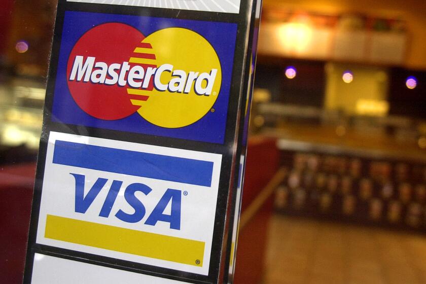 FILE - MasterCard and Visa credit card logos are shown at the entrance of a New York coffee shop, April 22, 2005. A deadline is looming for millions of businesses who may be entitled to a payout in a $5.5 billion antitrust settlement with Visa and Mastercard. The settlement stems from a 2005 lawsuit that alleged merchants paid excessive fees to accept Visa and Mastercard credit cards, and that Visa and Mastercard and their member banks acted in violation of antitrust laws. (AP Photo/Mark Lennihan, File)