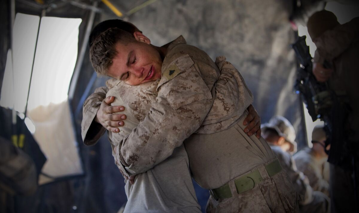 Cpl. Garrett Doty, right, hugs Corpsman Ruel Gojar after they returned from patrol in the Wishtan area of Sangin, Afghanistan