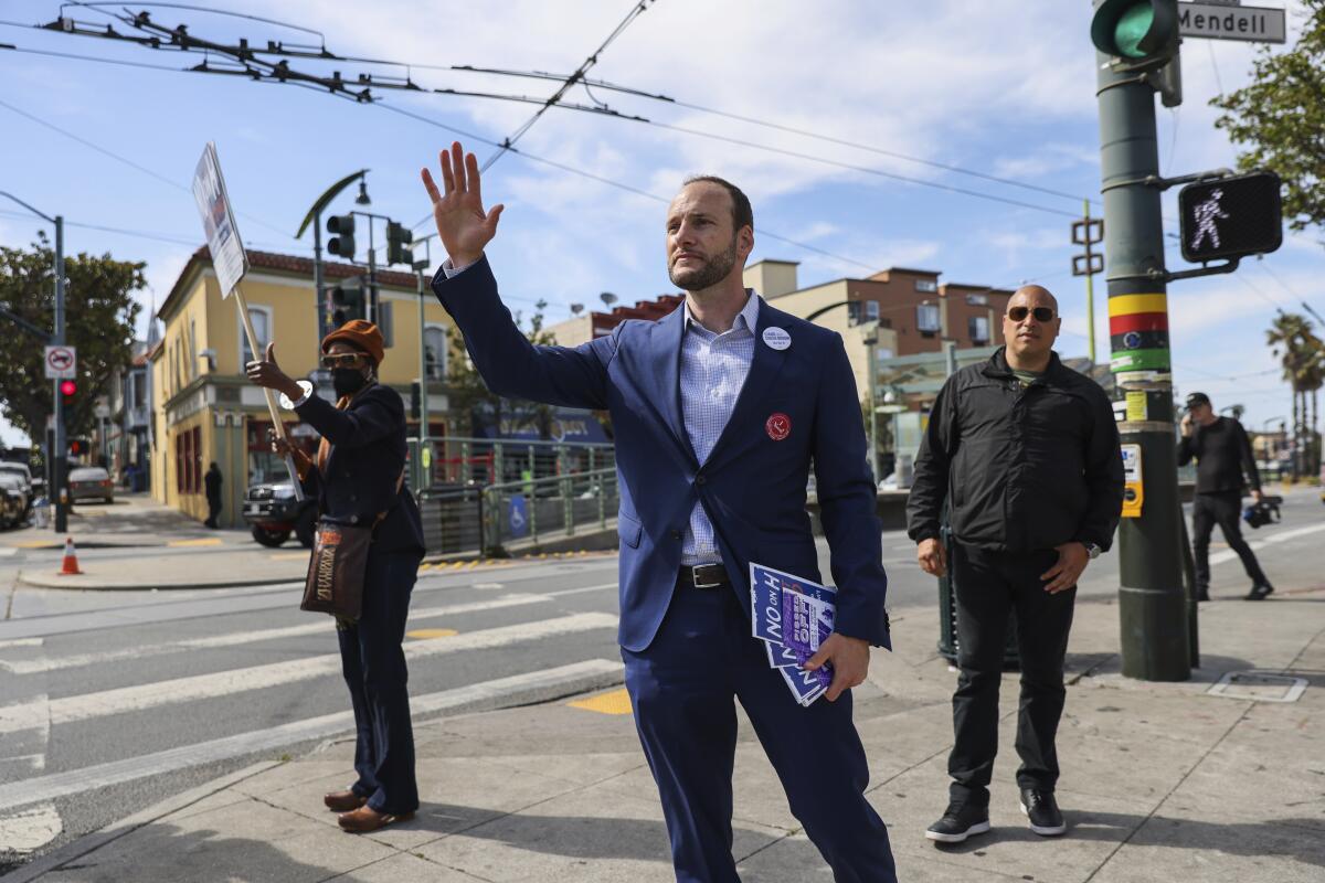 FILE -District Attorney Chesa Boudin waves at cars honking in support as he canvasses on 3rd Street in the Bayview neighborhood ahead of the recall on Tuesday, June 7, 2022, in San Francisco. Boudin says, Thursday, Aug. 4, he will not run for his old seat in the November election. (Gabrielle Lurie/San Francisco Chronicle via AP,File)