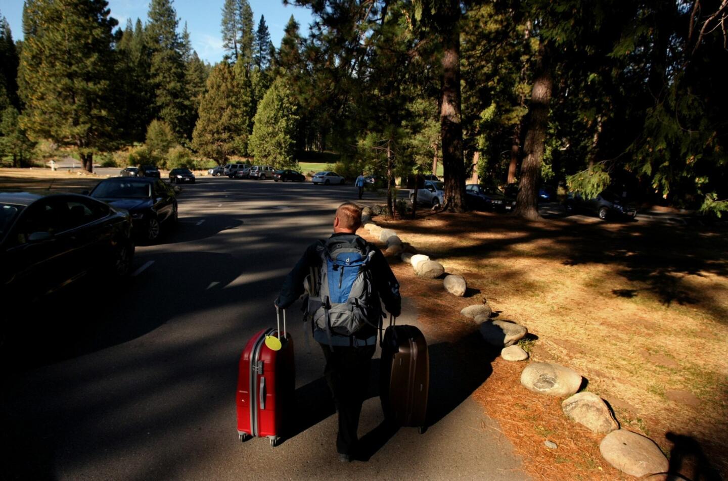Bastian Ziegler, a Yosemite visitor from Stuttgart, Germany, leaves the Wawona Hotel on Wednesday. Campground and hotel reservations inside the national park were no longer being honored because of the national park's closure; visitors were issued refunds and told they could no longer enter the park.
