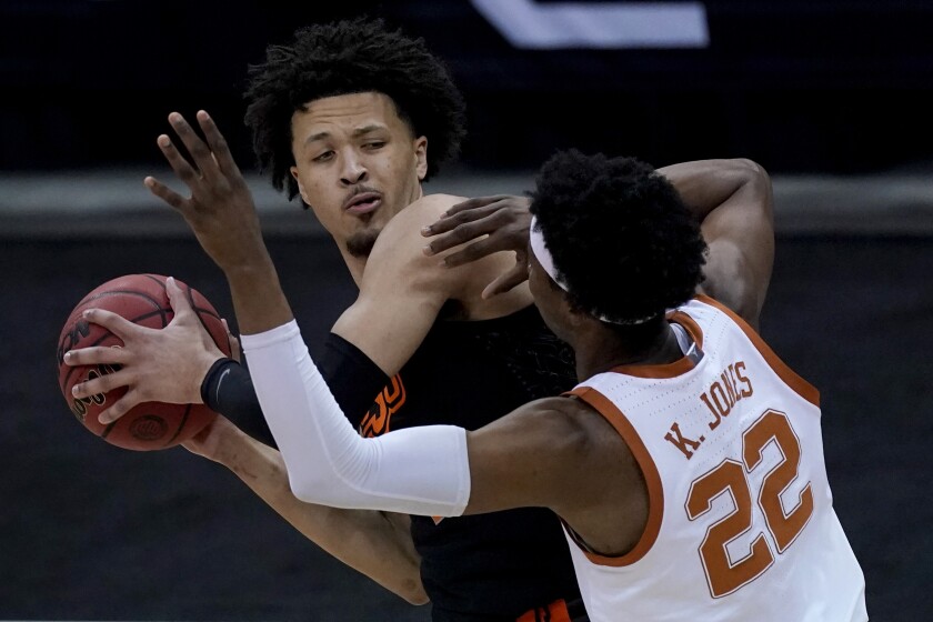 Oklahoma State's Cade Cunningham looks to pass under pressure from Texas' Kai Jones (22) during the first half of an NCAA college basketball game for the Big 12 tournament championship in Kansas City, Mo, Saturday, March 13, 2021. (AP Photo/Charlie Riedel)