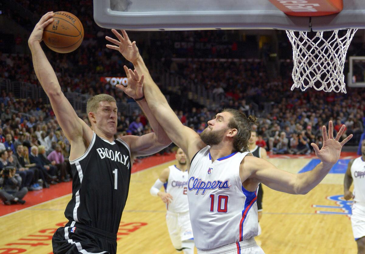 Spencer Hawes tries to block a shot from Brooklyn center Mason Plumlee during the first half of the Clippers' 123-84 rout of the Nets at Staples Center.