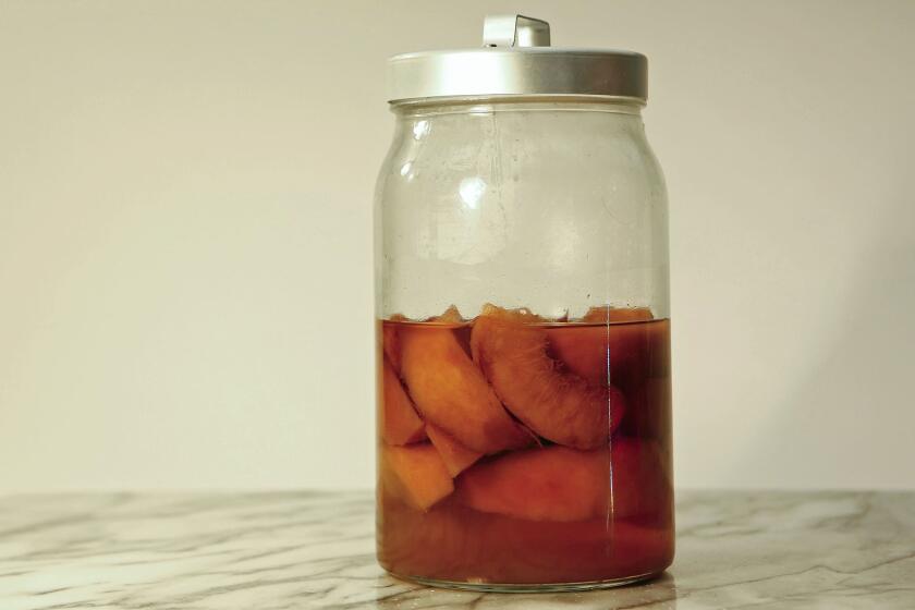 LOS ANGELES, CA. - AUGUST 6, 2015: Peahes, left, and strawberries, right, infused in liquor for food shoot in Los Angeles Times studio on August 6, 2015. (Anne Cusack/Los Angeles Times)