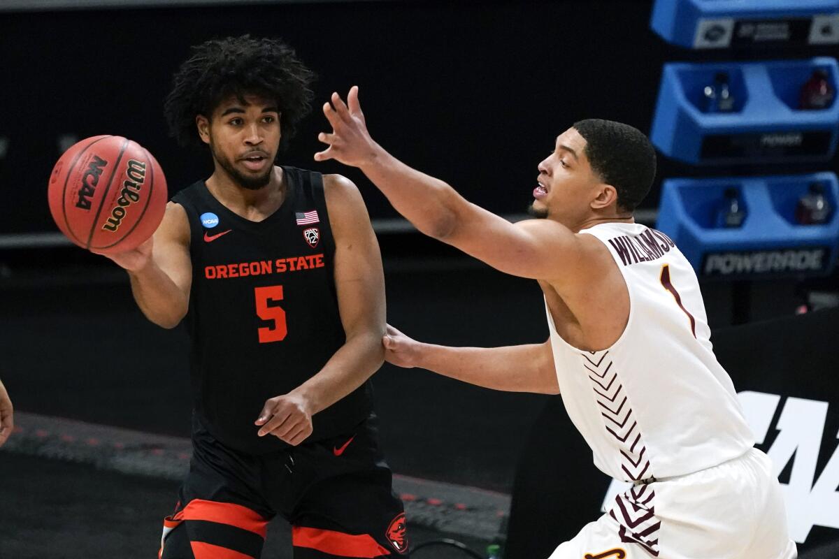 Oregon State guard Ethan Thompson passes around Loyola Chicago guard Lucas Williamson.