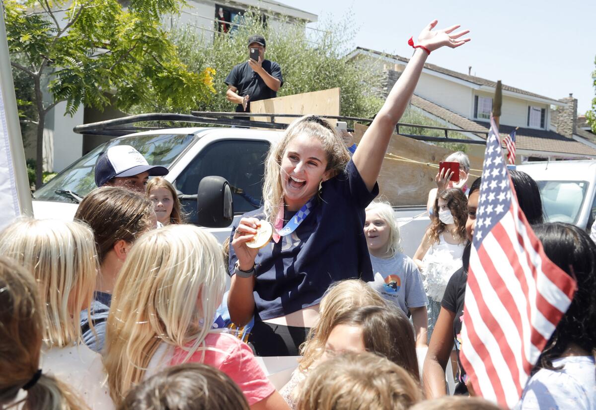 Maddie Musselman shows off her Olympic gold medal during a welcome home block party in Newport Beach in 2021.
