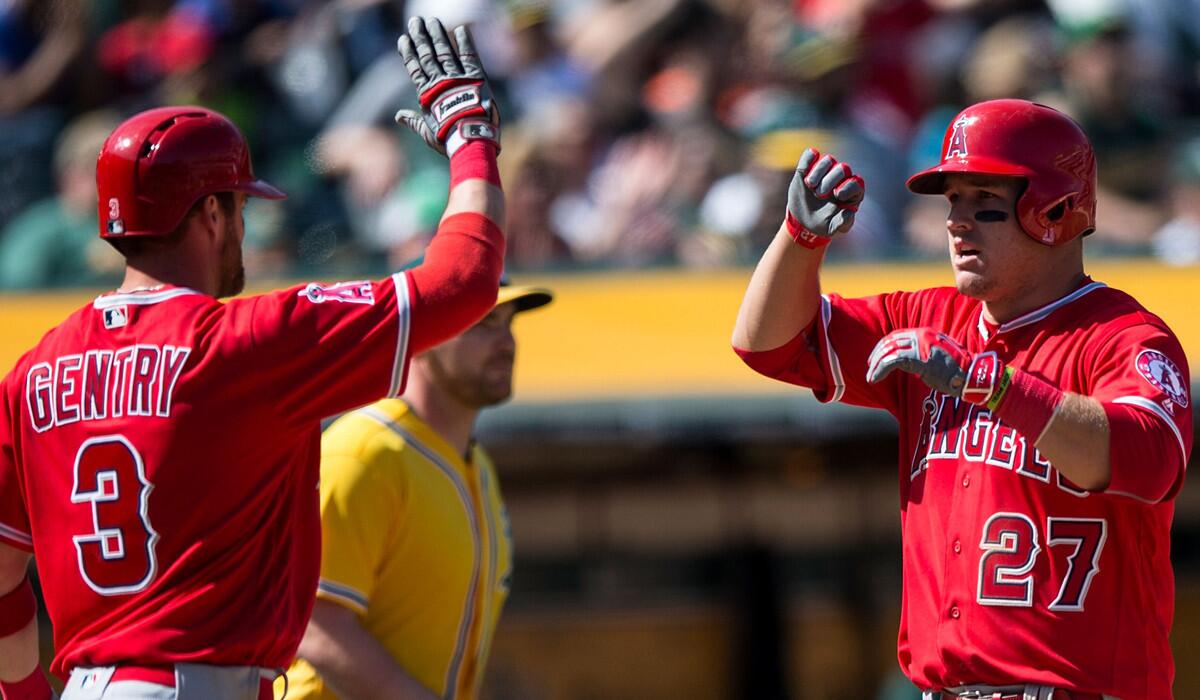 Angels's Mike Trout, right, celebrates with teammate Craig Gentry after both scored runs against the Oakland Athletics during the ninth inning on Wednesday.