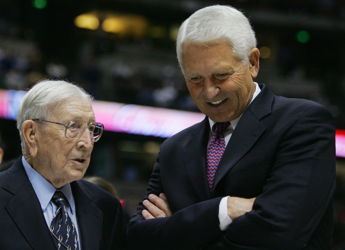 Former UCLA coach John Wooden, left, speaks with Arizona coach Lute Olson after a game in 2004.