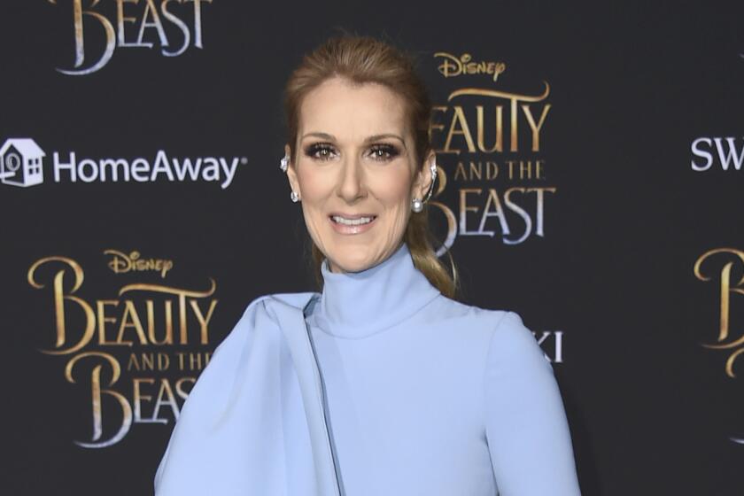 Celine Dion in a powder blue turtle neck gown posing for pictures