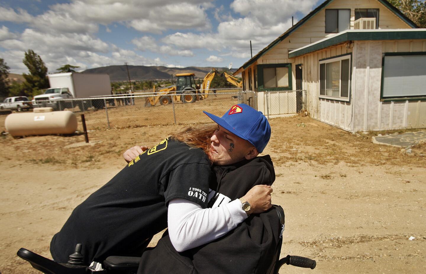 Jerral Hancock gets a hug from Lancaster High history teacher Jamie Goodreau at the May 2014 groundbreaking ceremony for Hancock's new home in Palmdale.