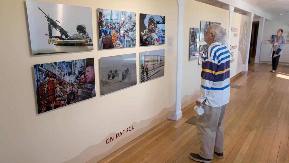 Tom Mortell looks a photography exhibition from Kimberly Millett titled "Operation Iraqi Freedom" at the Heroes Hall veterans museum at the OC Fair & Event Center on Thursday.