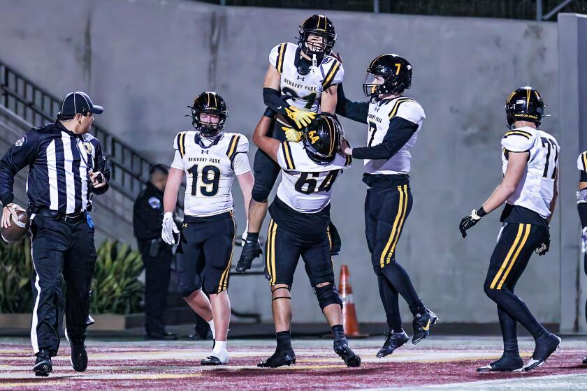 Record-setting receiver Shane Rosenthal of Newbury Park is lifted up by teammate Joel Gonzalez.