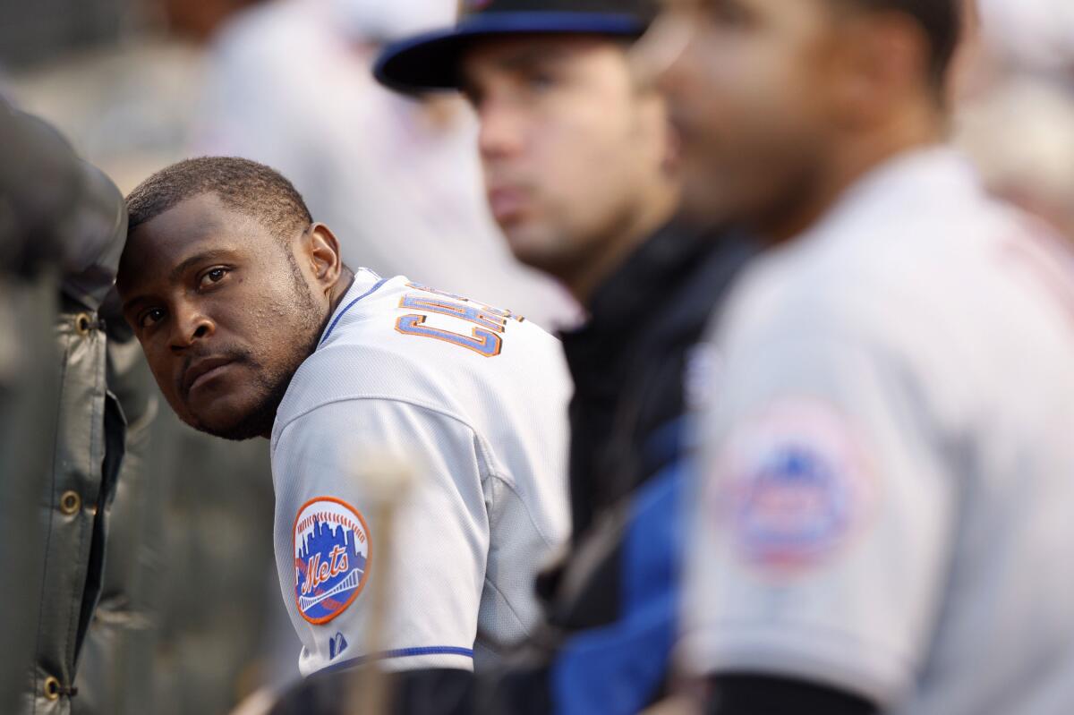 New York Mets second baseman Luis Castillo rests his head against the dugout rail.