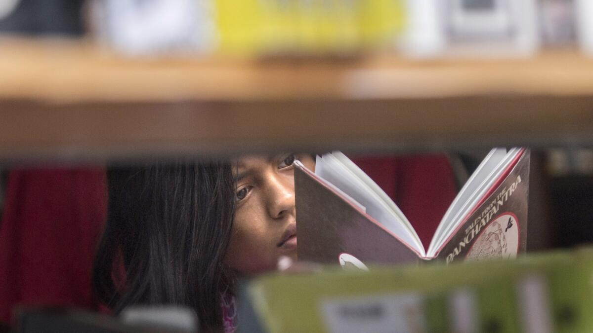 Betty Ordoña, 11, looks through a book shop at the Los Angeles Times Festival of Books on Sunday at USC.