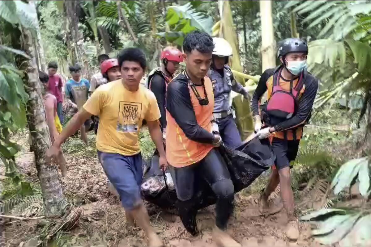 Rescuers carry a victim through a jungle