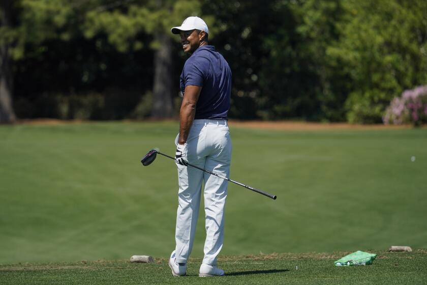 Tiger Woods waits to hit on the driving range during a practice round for the Masters golf tournament