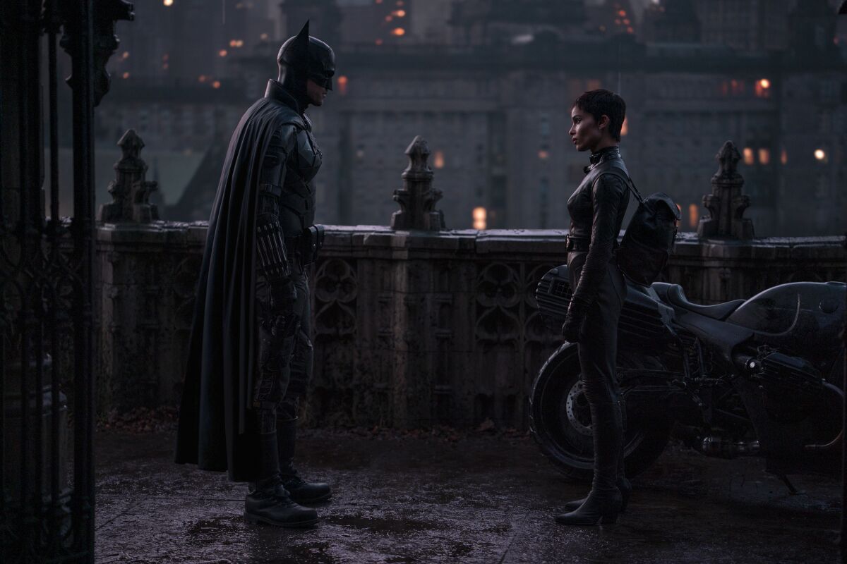 Robert Pattinson in a Batman costume standing across from Zoë Kravitz in a leather costume