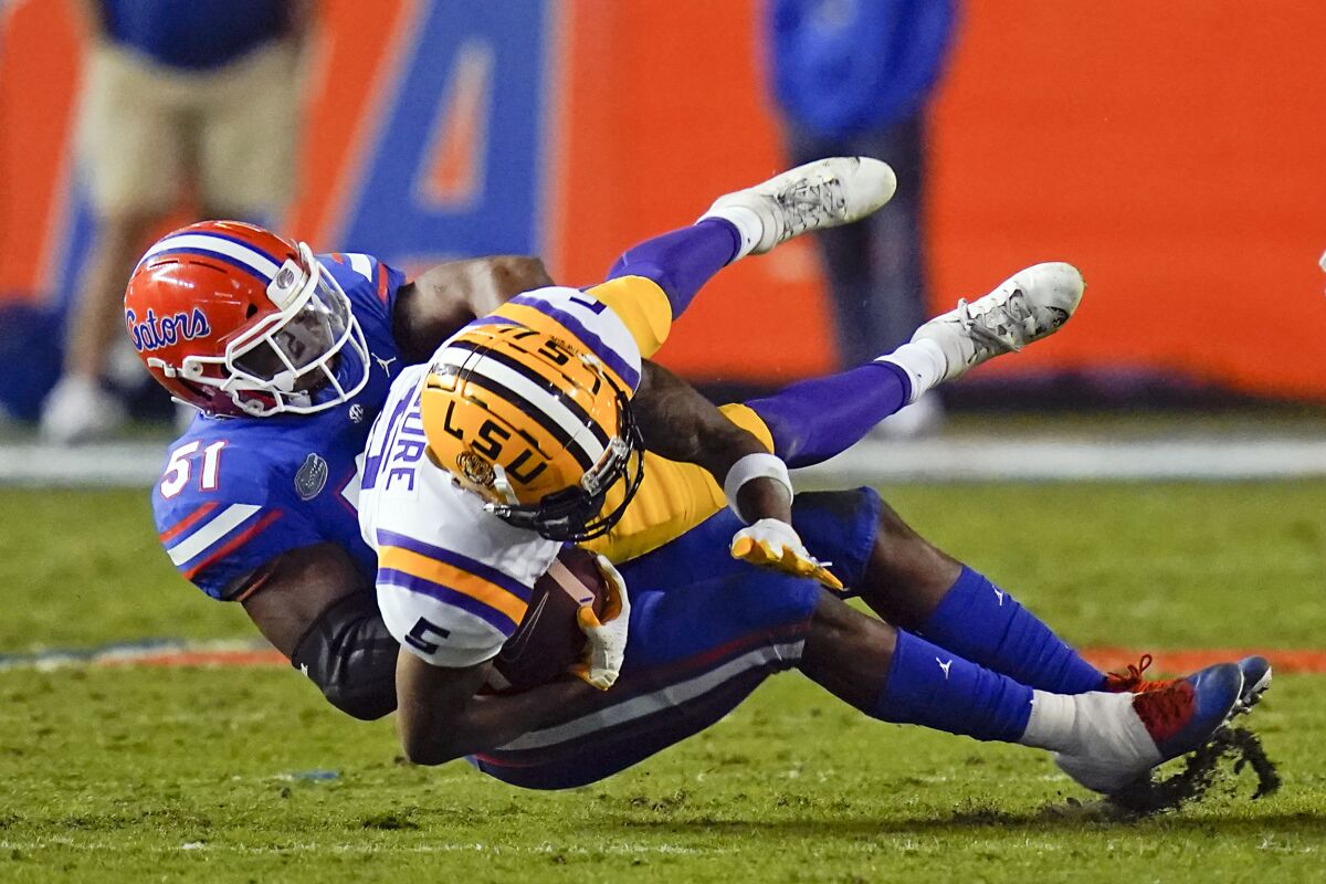 Florida linebacker Ventrell Miller (51) tackles LSU wide receiver Koy Moore after a reception during the first half of an NCAA college football game Saturday, Dec. 12, 2020, in Gainesville, Fla. (AP Photo/John Raoux)