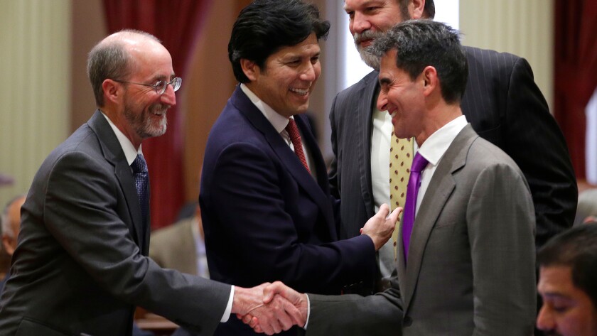 Sen. Mark Leno (D-San Francisco), right, receives congratulations from Sen. Steve Glazer (D-Orinda), left, and Senate President Pro Tem Kevin de León (D-Los Angeles), center, after lawmakers approved the 2016-17 state budget.