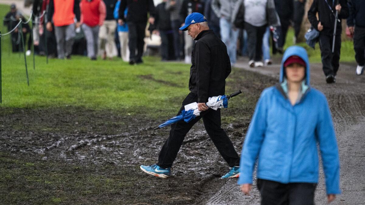Pathways are muddy after more than a six-hour rain delay during the first round of the Genesis Open at Riviera Country Club on Thursday.