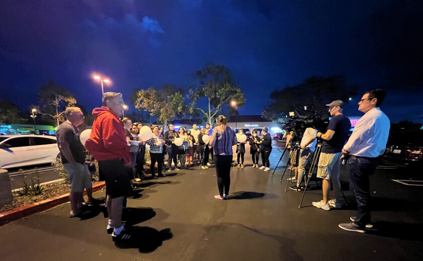 Attendees of a vigil outside a Stater Bros. store on Costa Mesa's Baker Street Wednesday hear words from Patricia Batchelor.