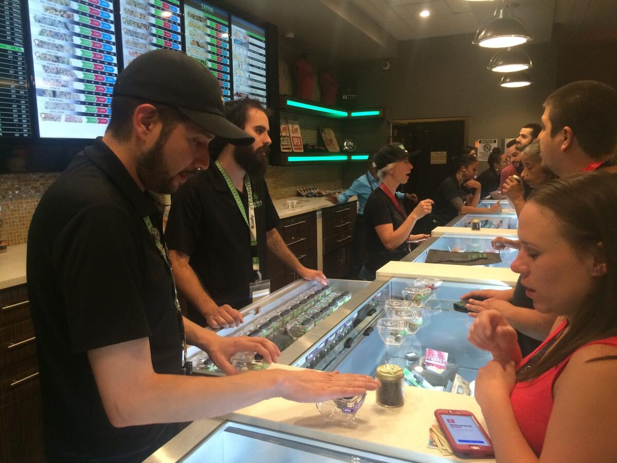 Employees at Las Vegas ReLeaf help customers select marijuana products early Saturday,the first day pot sales for recreational use became legal.