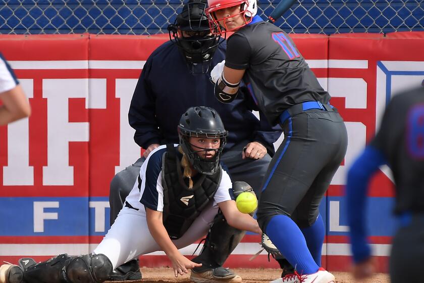 LOS ALAMITOS, CALIFORNIA APRIL 19, 2021-Los Alamitos High School softball catcher Sophia Nugent gets hit by a pitch during a recent game. (Wally Skalij/Los Angeles Times)